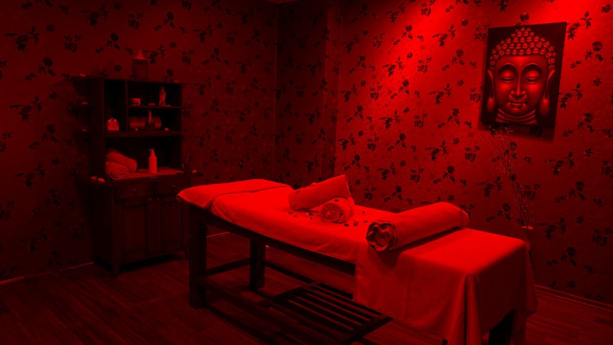 Professional red light therapy treatment room with massage table in a modern wellness clinic