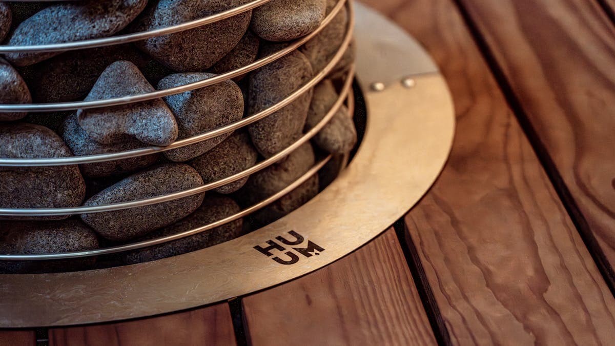 Close-up of sauna heater stones with warm ambient lighting in a modern sauna